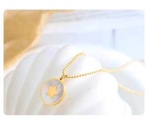 Macro detail of gold round bead chain with star cutout mother of pearl shell pendant