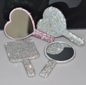 Detail of glittery rhinestone compact hand mirrors in heart, square and round shapes
