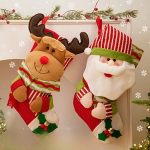 Chaussettes de Noël en tricot avec motifs renne et Père Noël suspendues à la cheminée