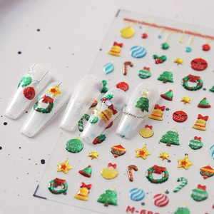 Christmas nail art stickers with festive trees and bells on white long fake nails