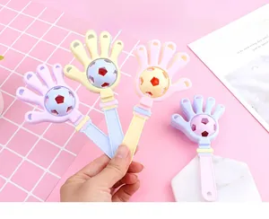 Close-up of macaron color creative hand clapper rattle with colorful soccer bell ball inside