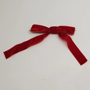 Macro shot of red velvet Christmas tree bow with gold metal clip on the back side