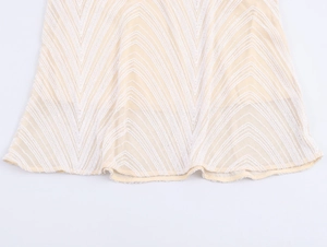 Detail of sequined wavy patterns and mesh fabric on a stylish beige V-neck dress