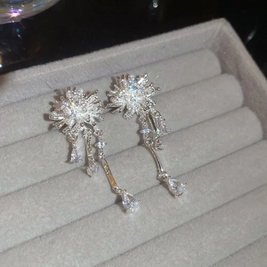 Detailed close-up of floral silver tassel earrings with pearls and cubic zirconia