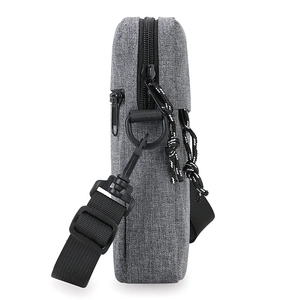Minimalist grey cross-body shoulder bag with black zippers and adjustable strap side view