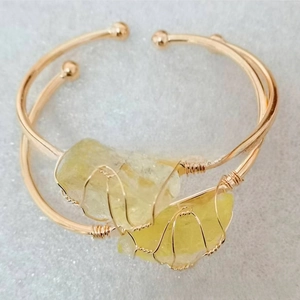 Detail of gold-plated open bangles with irregular raw crystals and wire wrapping