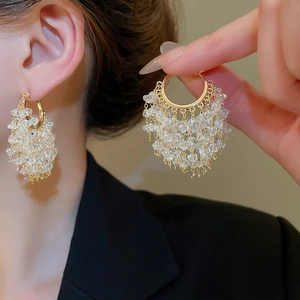 Detailed view of 18k gold plated hoop earrings with cascading clear crystal tassels