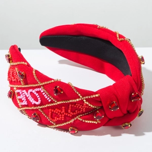 Dettaglio del cerchietto rosso annodato con perline LOVE e strass scintillanti a cuore