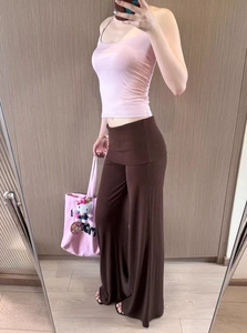 Detail of pink halter top and brown low-waist wide-leg knit trousers on a model