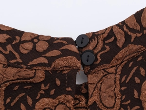 Gros plan de l'encolure jacquard marron foncé avec col rond et boutons noirs circulaires
