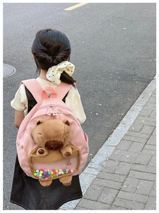 Pink toddler backpack featuring a cute plush capybara inside a colorful ball compartment