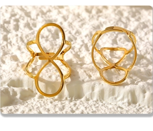 Macro shot of two gold PVD plated stainless steel open rings with geometric figure 8 design
