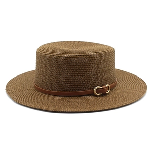 Détail du chapeau de paille tressé marron foncé avec bande en cuir et boucle en métal
