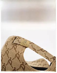Detail of adjustable bronze buckle on jacquard logo baseball cap with premium fabric texture