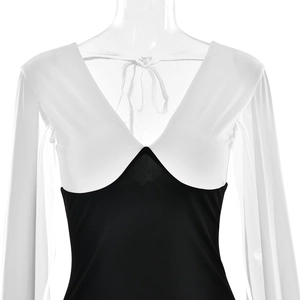 Detail of elegant V-neck dress with sheer white chiffon sleeves and black contrast panel