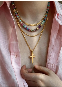 Macro shot of layered 18k gold plated necklaces featuring cross pendant and colorful beads
