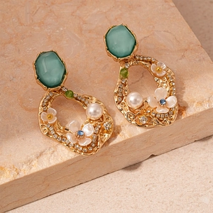 Vintage gold earrings with green gemstone, pearls, and sparkling floral details