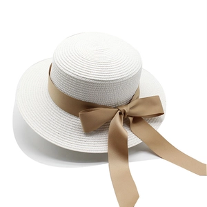 Dettaglio della trama del cappello di paglia bianco con nastro kaki e fiocco elegante
