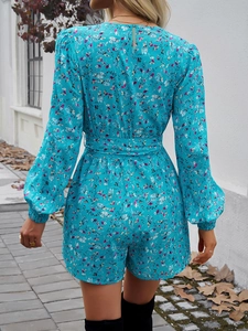 Dettaglio tutina blu floreale da donna con polsini elastici e chiusura lampo sul retro