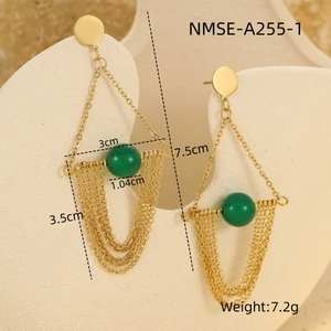 Detailed macro view of gold tassel earrings with green beads and geometric fringe