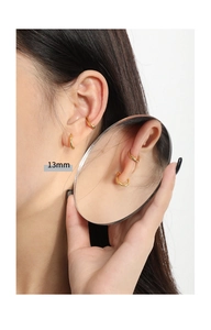 Detailed close-up of 13mm minimalist gold circle hoop earrings and a textured ear cuff