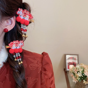 Detail of red embroidered horse hair clips with tassels and festive lucky characters