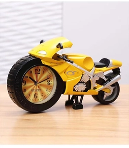 Detail view of the yellow motorcycle alarm clock with quartz movement on a wood surface