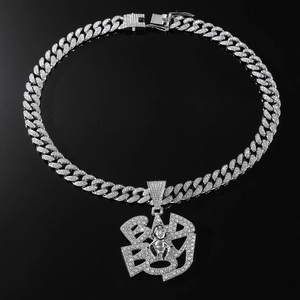 Macro shot of silver Cuban chain necklace with iced out BAD BOY pendant and rhinestones