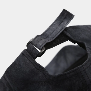 Close-up of the adjustable strap and buckle on the back of a black brushed fabric cap