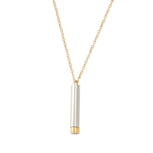 Detail of silver cylindrical pendant with gold accent on a thin gold chain necklace