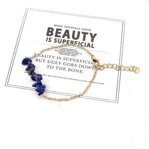 Detail of a gold chain bracelet featuring dark blue irregular crystals with a lobster clasp
