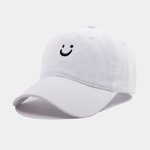 Close-up of black embroidered smiley face on white cotton vintage baseball cap