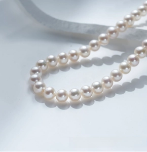 Dettaglio di perle d'acqua dolce bianche lucide con chiusura a fiore in argento S925