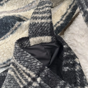 Detailed close-up of grey and white striped plush faux shearling tote bag with black lining