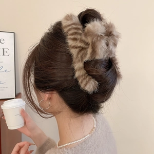 Detail view of large plush faux fur hair claw clip in brown tiger print for winter