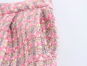 Vue détaillée de la texture du tissu tweed rose blanc gris et de la poche du pantalon décontracté