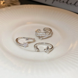 Macro detail of three silver star rings with zircon inlay on a ceramic dish