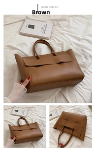 Close-up of large brown faux leather tote bag showing smooth matte texture and stitching