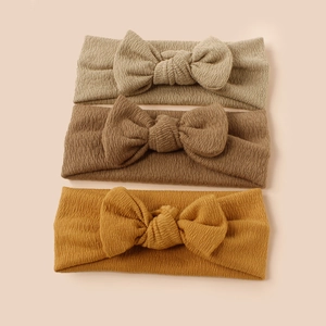 Three-piece baby headbands with ribbed knit texture and oversized bows in earthy tones