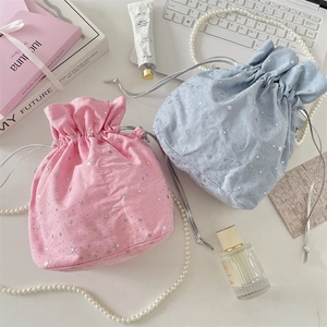 Detail of pink and blue canvas drawstring bags with silver star patterns and cord