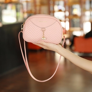 Pink shell crossbody bag with wave pattern quilting and elegant pearl pendant detail