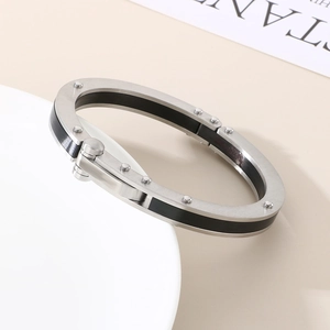 Close-up of industrial steel bracelet featuring black inner ring and rivet details