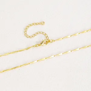 Detail of 18k gold plated melon seed chain with lobster clasp and extension on texture
