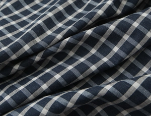 Detailed view of navy blue and white plaid fabric with natural woven texture and soft folds