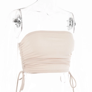 Vue détaillée du crop top bustier beige avec cordons de serrage latéraux et fronces