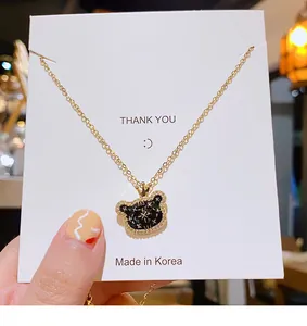 Détail du collier ours doré avec couronne, émail noir et reflets étoilés brillants