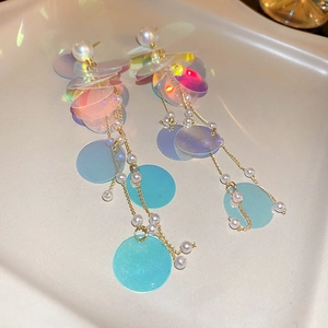 Y2K style laser sequins long tassel earrings with faux pearls on a beige tray