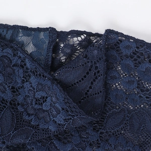 Close-up of deep blue lace fabric showing detailed floral texture and sewing craftsmanship