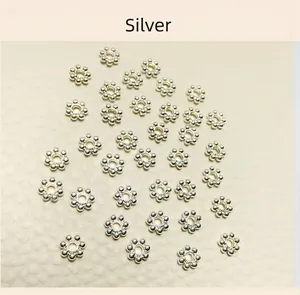 Detailed view of silver snowflake spacer beads for jewelry making with thick silver plating