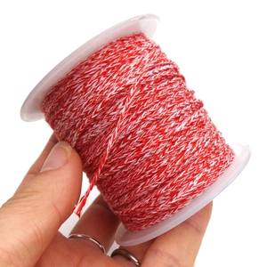 Three-strand red and white braided cotton cord on spool for DIY jewelry making and crafts